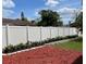 Bright red mulch and green shrubs line a white vinyl fence in the home's backyard at 714 West Ct, Longwood, FL 32750