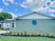 Side of the house features exterior textured walls, beautiful flowerbeds, and a small blue decorative wreath at 714 West Ct, Longwood, FL 32750