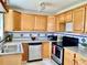 Close up view of kitchen, including wooden cabinets, stainless steel appliances, and granite countertops at 714 West Ct, Longwood, FL 32750