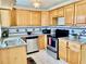 Well-lit kitchen boasting stainless steel appliances, wooden cabinets, and patterned backsplash at 714 West Ct, Longwood, FL 32750