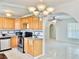 Sunlit kitchen featuring wooden cabinets, stainless steel appliances, and a decorative tiled backsplash at 714 West Ct, Longwood, FL 32750