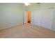 Bedroom with light green walls, beige carpet, and a double closet with white doors at 790 Blake Ln, The Villages, FL 32162