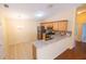 Open kitchen features stainless steel appliances, wood cabinetry, and neutral counters with a breakfast bar at 790 Blake Ln, The Villages, FL 32162