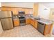 Bright kitchen featuring stainless steel appliances, light wood cabinets, and patterned backsplash at 790 Blake Ln, The Villages, FL 32162