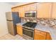 The kitchen features stainless steel appliances, wood cabinets, and light countertops at 790 Blake Ln, The Villages, FL 32162