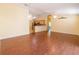 Spacious living room with laminate wood floors leads to an open kitchen featuring stainless appliances and wooden cabinets at 790 Blake Ln, The Villages, FL 32162