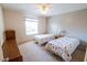 Spacious bedroom with two twin beds, a neutral color scheme, and ample natural light for a relaxing ambiance at 8201 Se 169Th Palownia Loop, The Villages, FL 32162