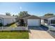 Charming single story home featuring an attached garage and well maintained front lawn and white picket fence at 8201 Se 169Th Palownia Loop, The Villages, FL 32162