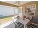 The screened in patio has a ceiling fan and is set up with a table and seating for outdoor enjoyment at 8201 Se 169Th Palownia Loop, The Villages, FL 32162
