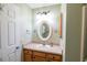 Well-lit bathroom featuring wood cabinets, an oval mirror, and neutral decor at 8233 Se 169Th Palownia Loop, The Villages, FL 32162