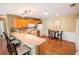 Eat-in kitchen with a breakfast bar, wood cabinets, and a full complement of white appliances at 8233 Se 169Th Palownia Loop, The Villages, FL 32162