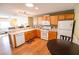 Bright kitchen with a breakfast bar, wooden cabinets, white appliances, and hardwood floors at 8233 Se 169Th Palownia Loop, The Villages, FL 32162