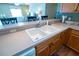 Bright kitchen featuring a white double sink, wooden cabinets, and open layout to the living area at 8233 Se 169Th Palownia Loop, The Villages, FL 32162
