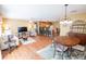 Open-concept living space with hardwood floors, a dining area, and a view into the kitchen at 8233 Se 169Th Palownia Loop, The Villages, FL 32162