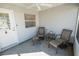 Relaxing screened-in porch featuring tile flooring, comfortable seating, and a ceiling fan at 8233 Se 169Th Palownia Loop, The Villages, FL 32162