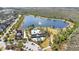Aerial view of community pool and splash pad, lake, and community center with lush landscaping and trees at 8549 Lovett Ave, Orlando, FL 32832