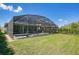 Green backyard, featuring a screened pool and patio, perfect for entertaining at 8549 Lovett Ave, Orlando, FL 32832