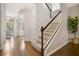 Inviting entryway featuring hardwood floors, a staircase with white railings and a glimpse into the living area at 8549 Lovett Ave, Orlando, FL 32832