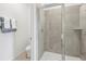 Modern bathroom showcasing a glass-enclosed shower with tiled walls and a commode at 917 Pearlwood Loop, Eagle Lake, FL 33839