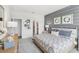 Stylish bedroom featuring a gray accent wall, comfortable bed, elegant decor, and ample natural light at 917 Pearlwood Loop, Eagle Lake, FL 33839