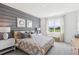 Beautiful bedroom featuring a gray accent wall, large window, plush bedding, and elegant decor at 917 Pearlwood Loop, Eagle Lake, FL 33839