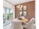 Elegant dining room with wooden accent wall, round table and sliding door access to outdoor patio at 917 Pearlwood Loop, Eagle Lake, FL 33839