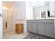 Well-lit bathroom featuring double sink vanity, gray cabinets, blue rug, and glass shower with white tile at 9513 Amber Chestnut Way, Winter Garden, FL 34787