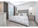 Bright bedroom featuring a large window, tufted headboard, bedside tables and lamps at 9513 Amber Chestnut Way, Winter Garden, FL 34787