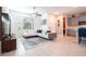 Open-concept living room features a white sectional couch, modern decor, and flows into the kitchen at 9513 Amber Chestnut Way, Winter Garden, FL 34787