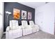 Theater room with three white reclining seats and movie posters on the dark accent wall at 9513 Amber Chestnut Way, Winter Garden, FL 34787