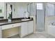 Bathroom showing a sink and vanity with white cabinets and a tiled, glass enclosed shower at 1019 Tuscan Hills Blvd, Davenport, FL 33897