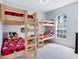 Bright bedroom featuring two sets of wooden bunk beds, carpeted floor, and arch window letting in natural light at 1019 Tuscan Hills Blvd, Davenport, FL 33897