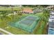 Aerial shot showcases tennis court, playground, and community center, all nestled amidst lush greenery and palm trees at 1019 Tuscan Hills Blvd, Davenport, FL 33897