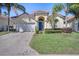 Charming single-story home featuring a terracotta roof, blue door, and well-maintained landscaping at 1019 Tuscan Hills Blvd, Davenport, FL 33897