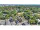 An aerial view highlighting the building, surrounding trees, with a baseball field and city skyline beyond at 1100 Delaney Ave # E13, Orlando, FL 32806