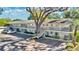 Apartment building featuring covered walkways, mature tree, and surface parking at 1100 Delaney Ave # E13, Orlando, FL 32806