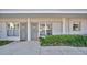 Exterior view of condos featuring neutral paint and landscaping, including green bushes and decorative plants in pots at 1100 Delaney Ave # E13, Orlando, FL 32806