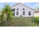 View of back exterior with large windows, screen porch, and a grassy yard at 1110 Stoneham Dr, Groveland, FL 34736