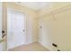 Well-lit laundry room featuring a wire shelf for storage and a white door at 1110 Stoneham Dr, Groveland, FL 34736