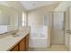 Bright main bathroom featuring a large mirror, soaking tub, and a separate glass shower at 1110 Stoneham Dr, Groveland, FL 34736