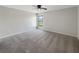 Neutral bedroom featuring carpet flooring, ceiling fan, and window with a view at 1172 Moyle Way, Mascotte, FL 34753