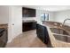 Modern kitchen featuring dark cabinets, granite countertops, stainless steel sink, and tile flooring at 1172 Moyle Way, Mascotte, FL 34753