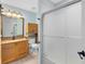 Bathroom featuring wooden cabinets, granite countertop, and a shower with sliding glass doors at 134 Woodleaf Dr, Winter Springs, FL 32708