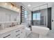 A modern bathroom with marble tiling, sleek fixtures, and a standalone soaking tub at 14815 Tullamore Loop, Winter Garden, FL 34787