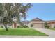 Charming single-story home boasts a lush lawn, two-car garage, and decorative tree and solar panels at 14815 Tullamore Loop, Winter Garden, FL 34787