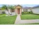 Inviting single-story home with lush landscaping, a walkway to the front door, and solar panels at 14815 Tullamore Loop, Winter Garden, FL 34787