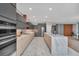 Modern kitchen with stainless steel appliances, marble island, and light wood cabinetry at 14815 Tullamore Loop, Winter Garden, FL 34787