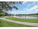 Scenic view of a tranquil pond with a walking path, bench seating, and lush greenery for a peaceful retreat at 14815 Tullamore Loop, Winter Garden, FL 34787