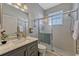 Clean bathroom features a vanity with marble countertop, a glass-enclosed shower, and bright lighting at 221 Calliope St, Ocoee, FL 34761