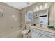 Bright bathroom with tub-shower combo, single vanity, and tiled walls at 221 Calliope St, Ocoee, FL 34761